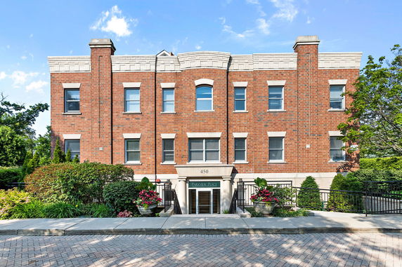 Front view of a two-story brick building with multiple windows and a central entrance.