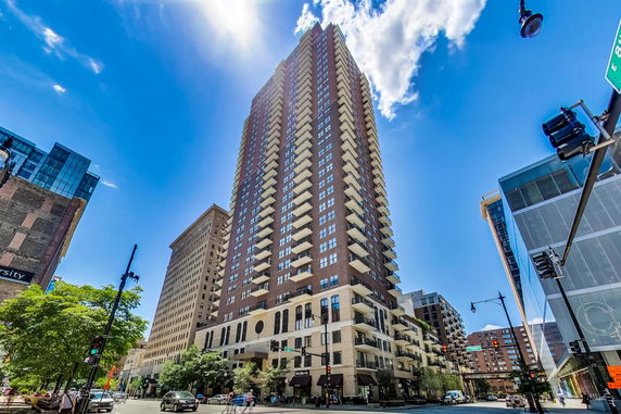 Tall multi-story building with balconies and large windows in an urban setting.