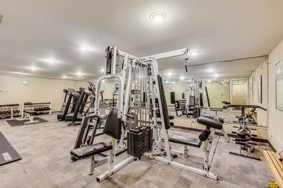 Indoor gym area with various exercise equipment, including a weight machine and treadmills.