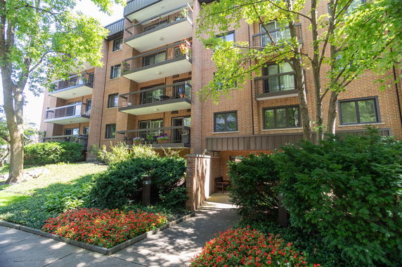 Front view of a multi-story brick apartment building with balconies.