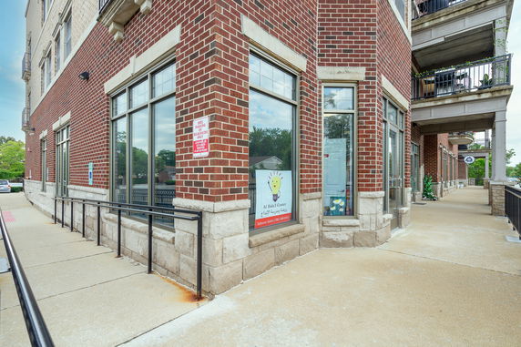Corner view of a brick building with large windows and a ramp.
