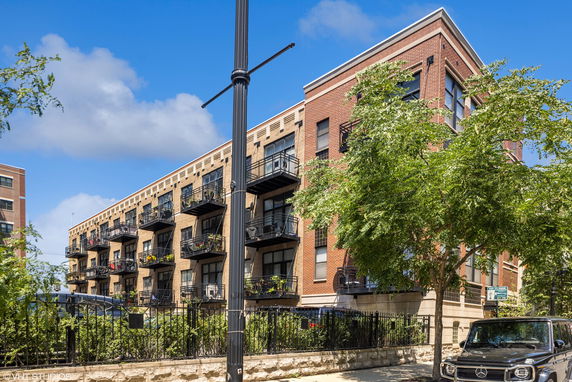 Front view of a multi-story apartment building with balconies.