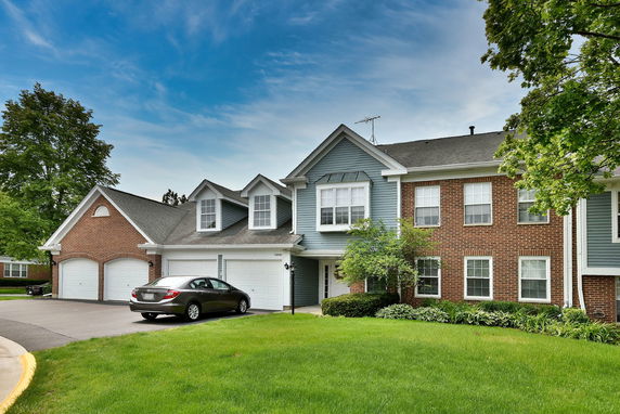 Front view of a two-story house with a double garage and mixed brick and siding exterior.