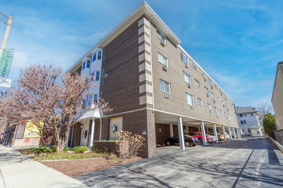 Front view of a multi-story apartment building with a brick exterior.