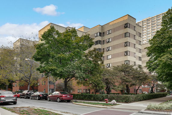 Front view of a multi-story apartment building with brick and concrete facade.