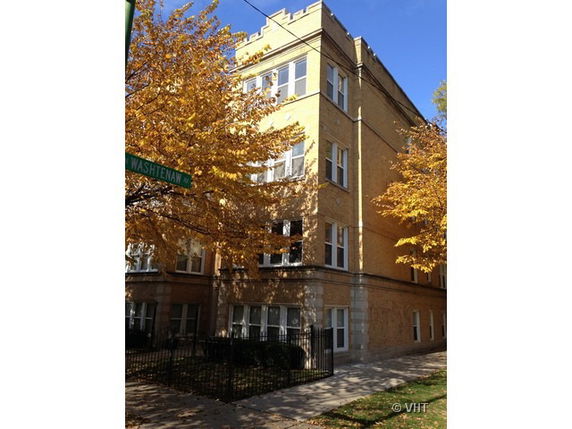 Front view of a multi-story brick apartment building.