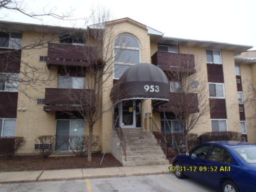 Front view of a multi-story apartment building with a central entrance canopy.