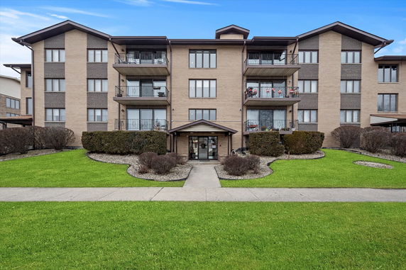 Front view of a multi-story residential building with balconies.