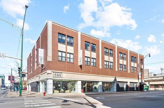 Front view of a multi-story commercial building with large windows and signage.