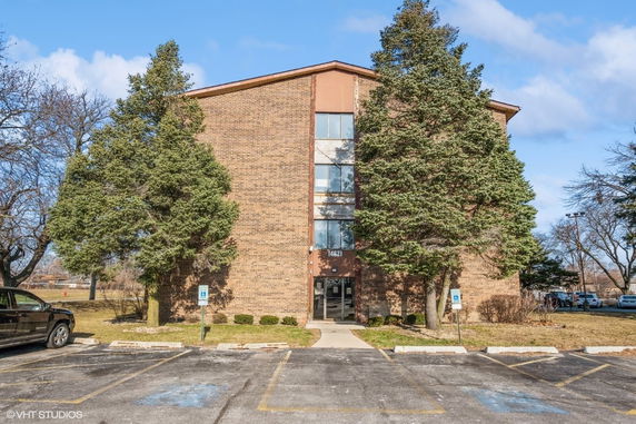 Front view of a multi-story brick building with a central entrance.