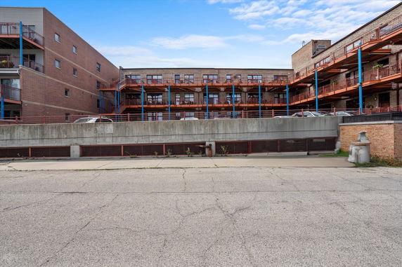 Front view of a multi-story building with brick exterior and balconies.