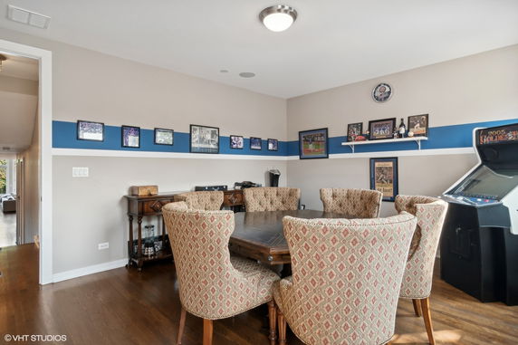 Room with a round table, patterned chairs, and wall decorations.