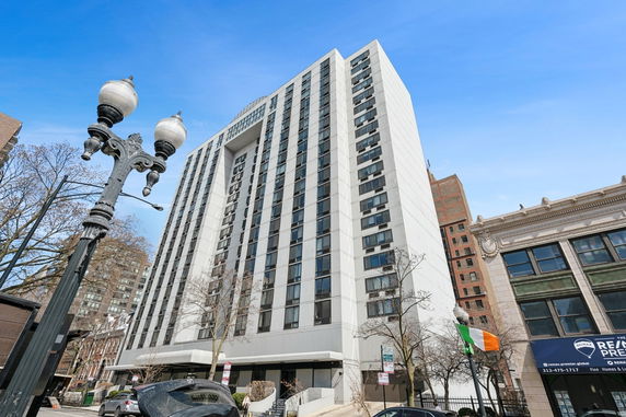 Front view of a multi-story residential building with numerous windows and a white exterior.