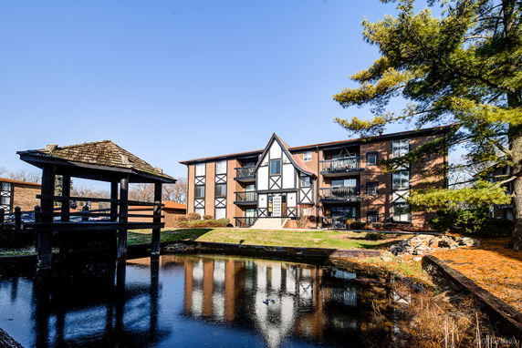 Front view of a multi-story building with balconies and Tudor-style architecture.