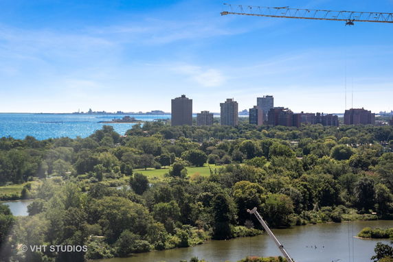 Panoramic view of a city skyline with tall buildings and a large body of water.