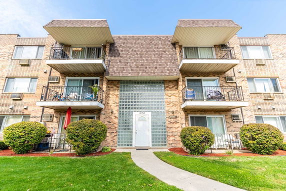 Front view of a three-story apartment building with balconies.