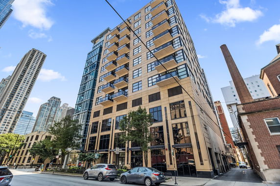 Front view of a multi-story building with balconies and large windows.