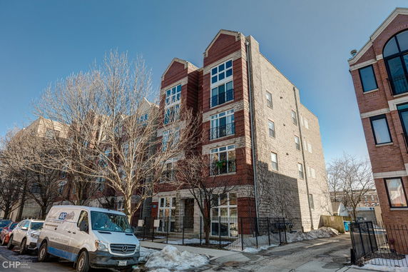 Front view of a multi-story brick building with large windows.