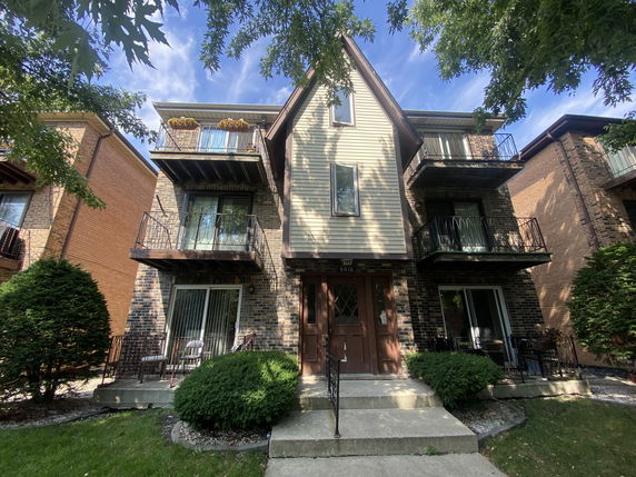 Front view of a multi-story residential building with balconies.