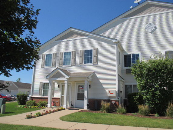 Front view of a two-story house with white siding and multiple windows.