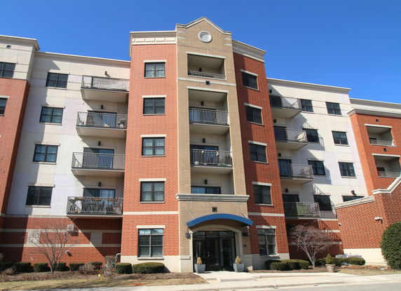 Front view of a multi-story apartment building with balconies.
