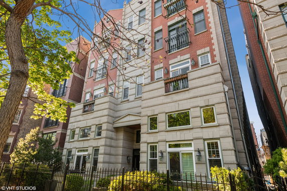 Front view of a multi-story residential building with brick and stone facade.