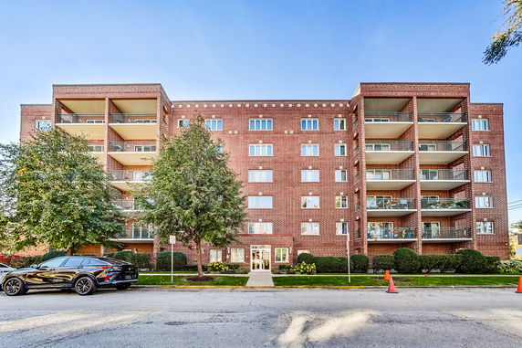 Front view of a multi-story apartment building with balconies.