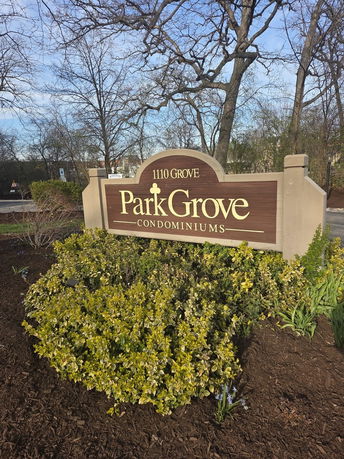 Sign for Park Grove Condominiums with shrubbery around it.