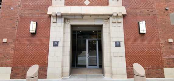 Front view of a building entrance with brick and stone detailing.