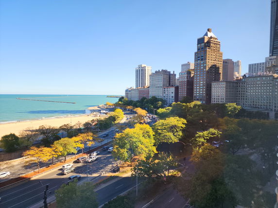 Panoramic view of a cityscape with tall buildings and a beach by a body of water.