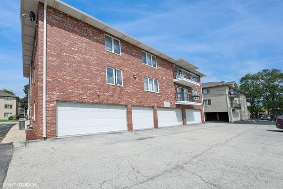 Front view of a multi-story brick building with multiple garages.