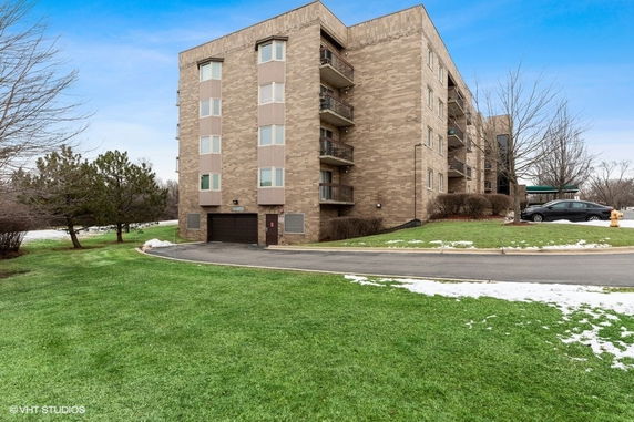 Front view of a multi-story apartment building with brick exterior.