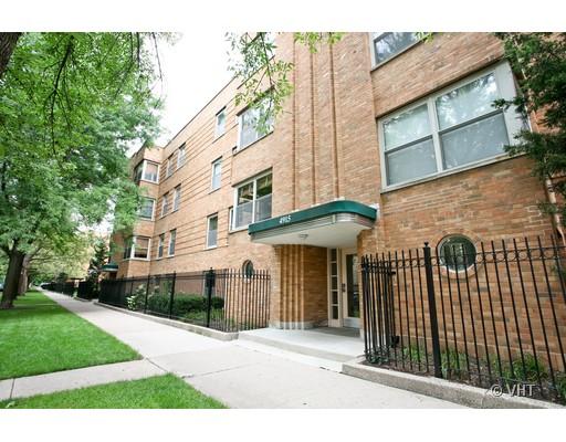 Front view of a multi-story brick apartment building with a green awning over the entrance.