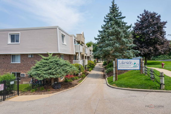 Front view of a multi-story condominium building with a sign for Lakeside Condominiums.