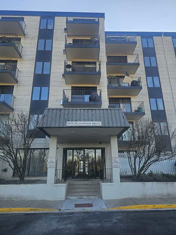 Front view of a multi-story apartment building with balconies.