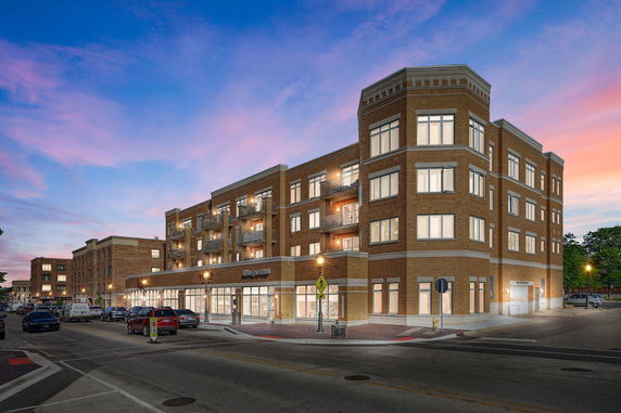 Front view of a multi-story building with a modern design and large windows.
