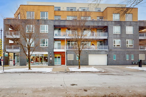 Front view of a multi-story residential building with a mix of brick and modern design features.