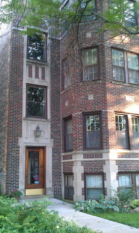 Front view of a multi-story brick building with multiple windows.