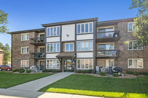 Front view of a three-story apartment building with balconies.