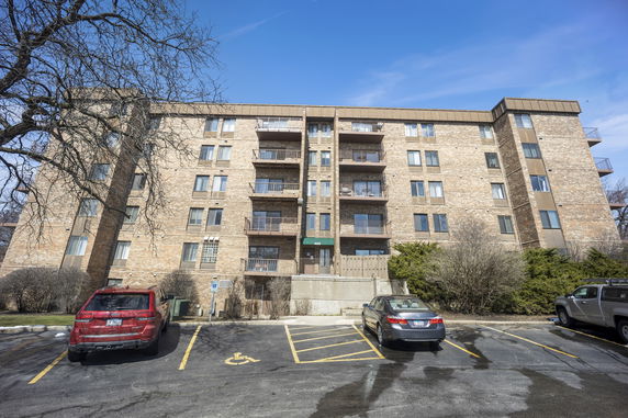 Front view of a multi-story apartment building with balconies.