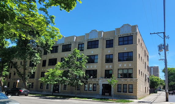Front view of a four-story brick apartment building.