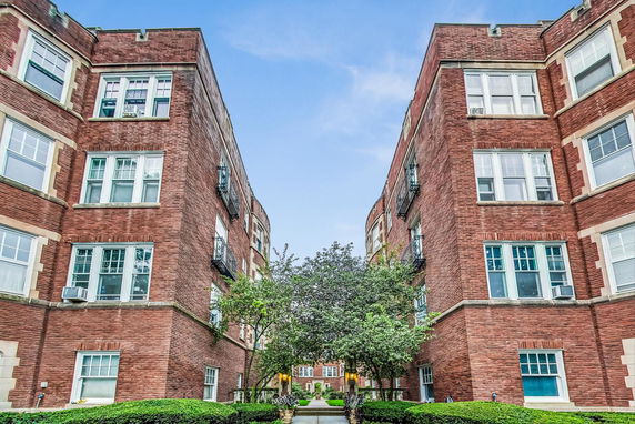 View of a multi-story brick apartment building with balconies.