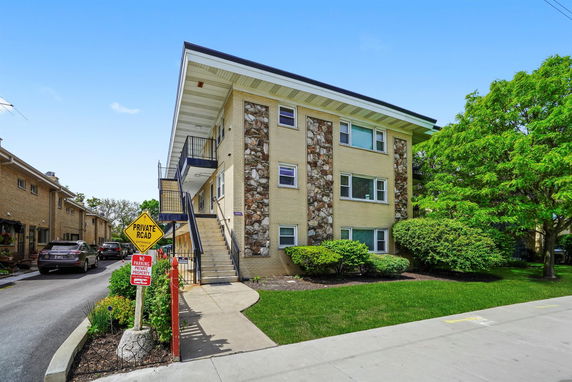 Front view of a three-story apartment building with external stairs.