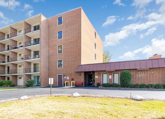 Front view of a multi-story brick building with balconies.