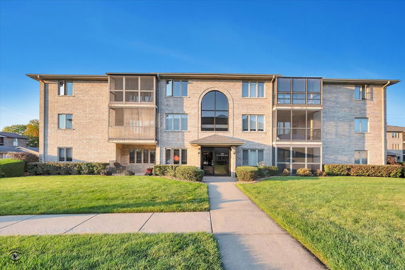 Front view of a three-story apartment building with balconies.