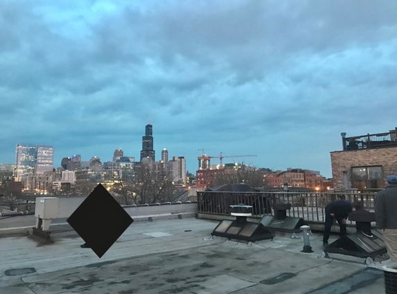 Rooftop area featuring various equipment with a city skyline in the background.