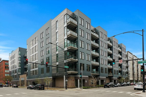 Front view of a multi-story apartment building with balconies.
