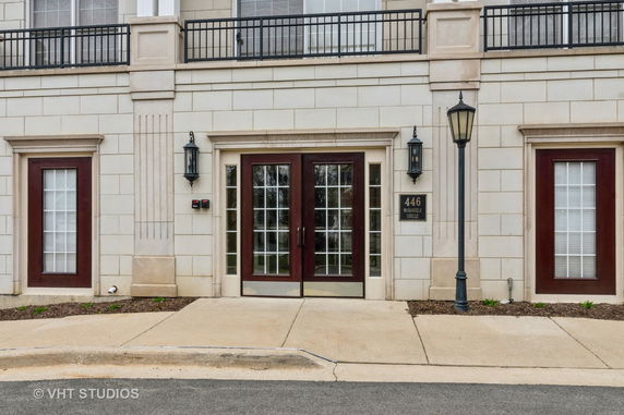 Front view of a building entrance with double doors and two flanking windows.