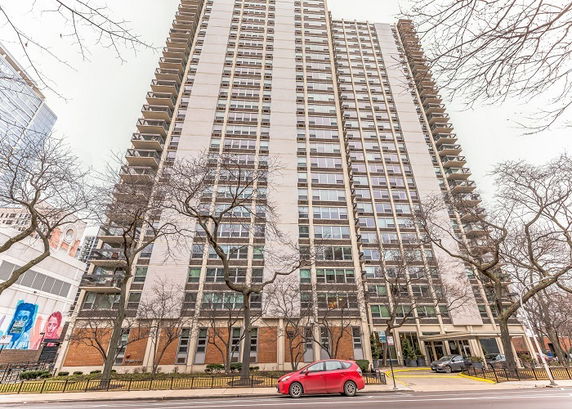 Front view of a high-rise apartment building with multiple floors and large windows.