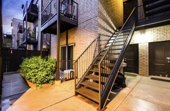 Front view of a multi-story building with outdoor staircase.